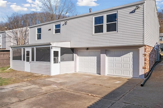 back of house featuring a sunroom and a garage