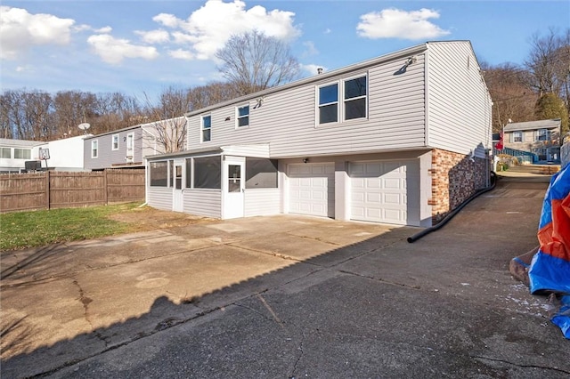 view of front of home featuring a sunroom and a garage