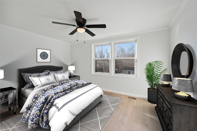 bedroom featuring ceiling fan, light hardwood / wood-style floors, and ornamental molding