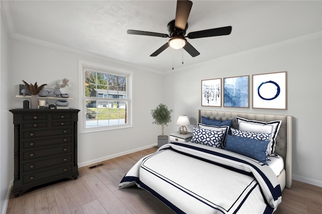 bedroom with light hardwood / wood-style flooring, ceiling fan, and crown molding