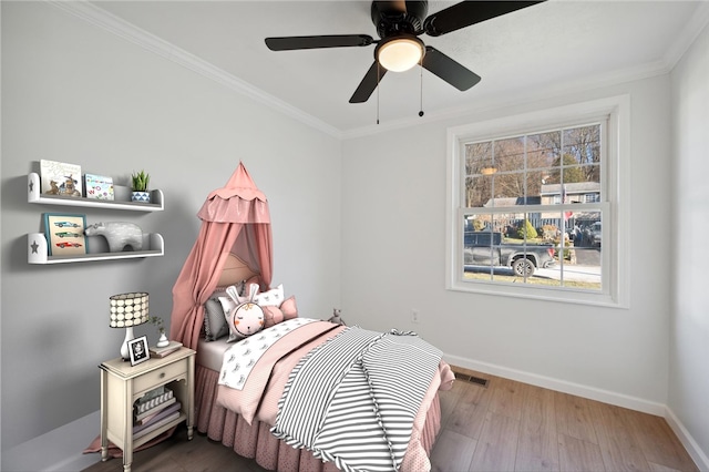 bedroom featuring hardwood / wood-style flooring, ceiling fan, and ornamental molding