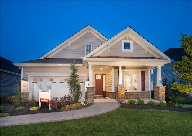 craftsman-style home with a front lawn, a porch, and a garage