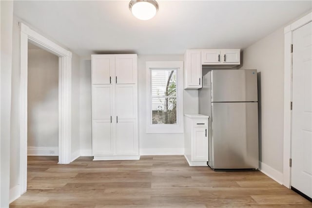 kitchen featuring white cabinetry, stainless steel fridge, and light hardwood / wood-style flooring