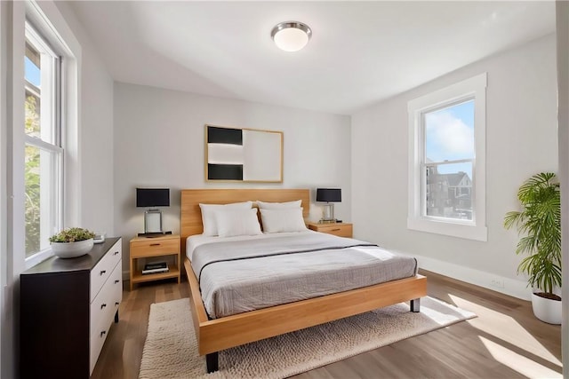 bedroom with hardwood / wood-style flooring and multiple windows