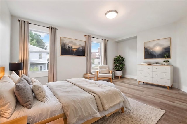 bedroom with light hardwood / wood-style floors and multiple windows