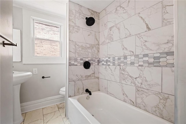 full bathroom featuring tiled shower / bath combo, toilet, and sink