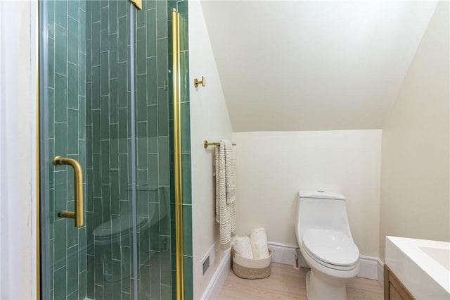 bathroom featuring hardwood / wood-style floors, vaulted ceiling, toilet, vanity, and a shower with shower door