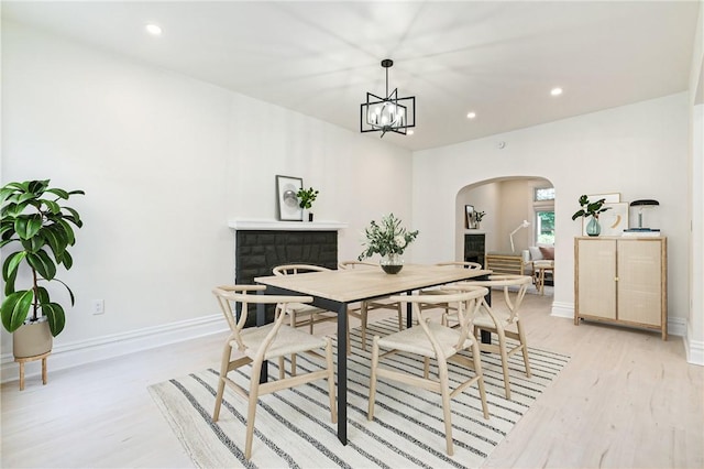 dining space with light hardwood / wood-style flooring and a chandelier