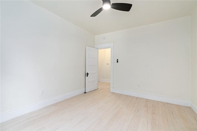 empty room with ceiling fan and light hardwood / wood-style flooring