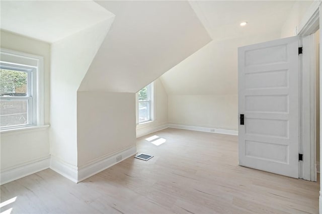 bonus room featuring light wood-type flooring and vaulted ceiling