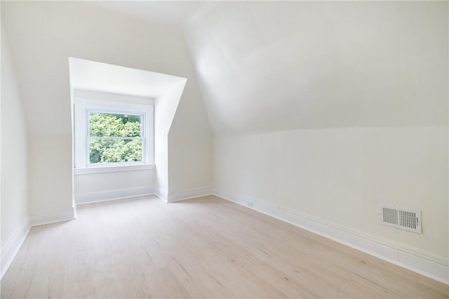 additional living space featuring light hardwood / wood-style floors and lofted ceiling