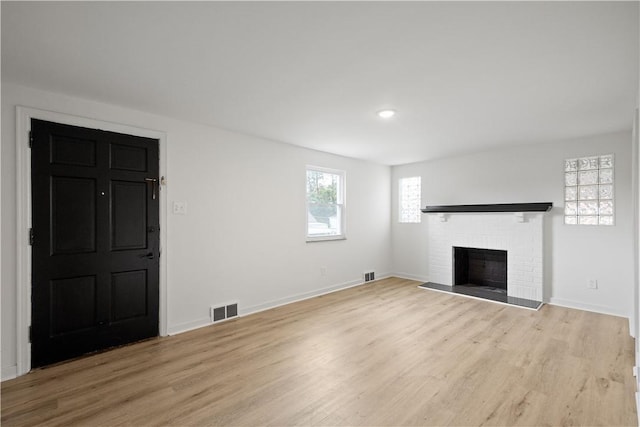 unfurnished living room with light wood-type flooring and a fireplace