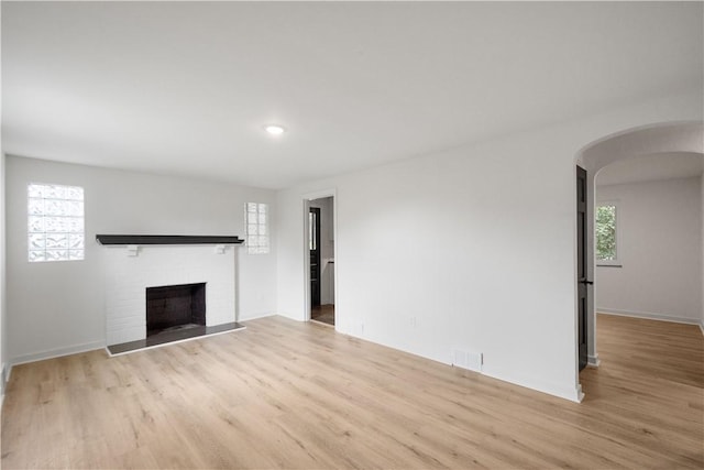 unfurnished living room featuring a fireplace and light hardwood / wood-style flooring