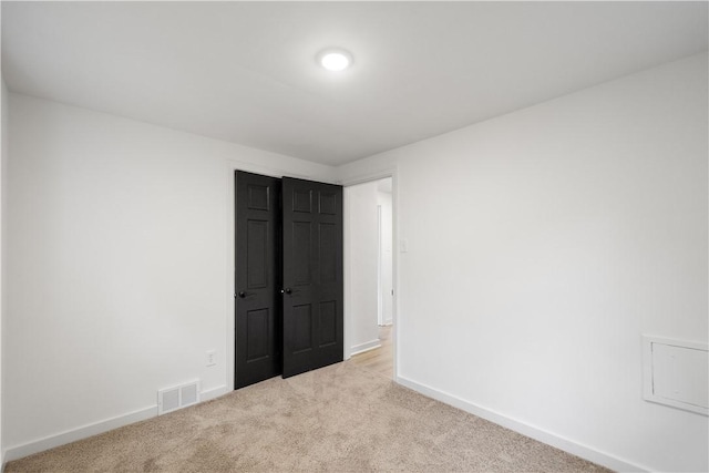 unfurnished bedroom with light colored carpet