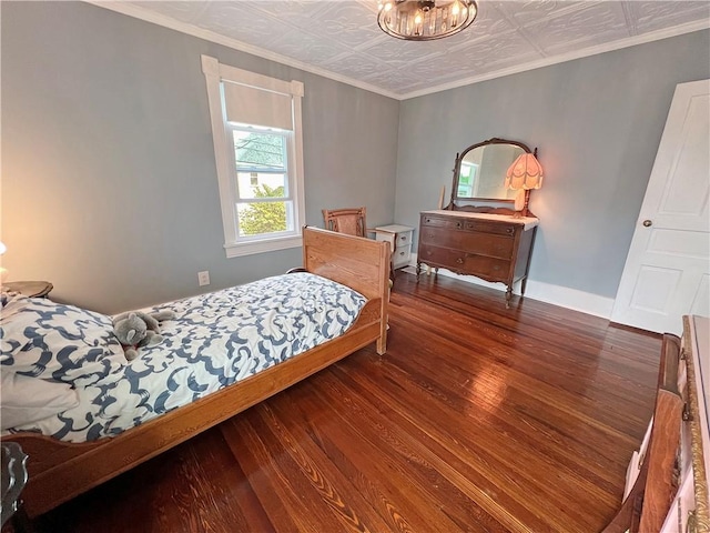 bedroom featuring crown molding, dark hardwood / wood-style flooring, and a chandelier