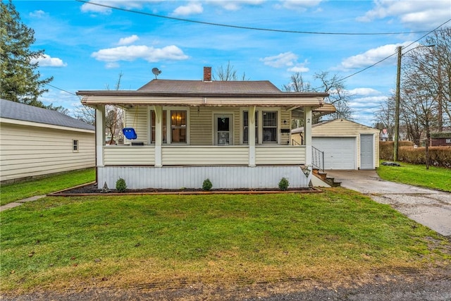 view of front of property with covered porch, an outbuilding, a garage, and a front lawn