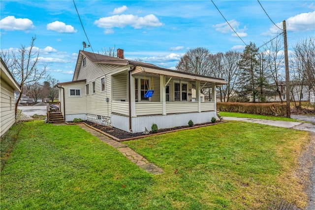 view of home's exterior with a yard and covered porch