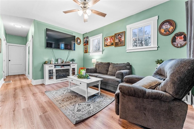 living room with light hardwood / wood-style floors and ceiling fan