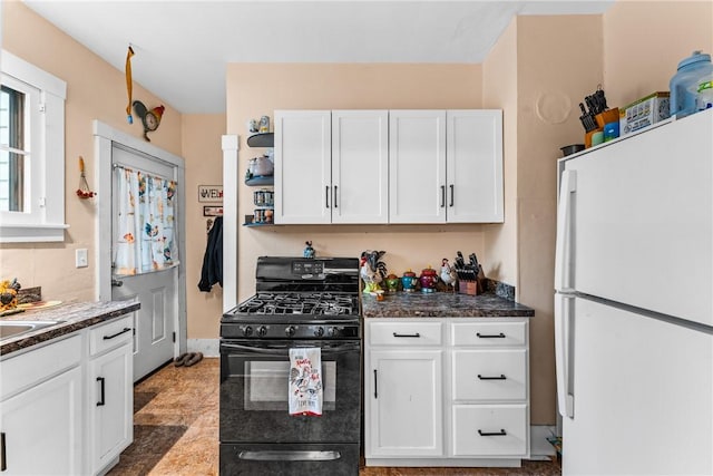 kitchen featuring white cabinets, black gas stove, and white fridge