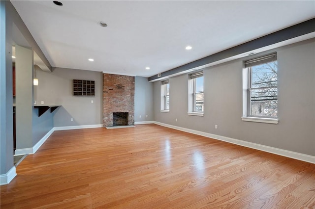 unfurnished living room featuring a fireplace and light hardwood / wood-style flooring