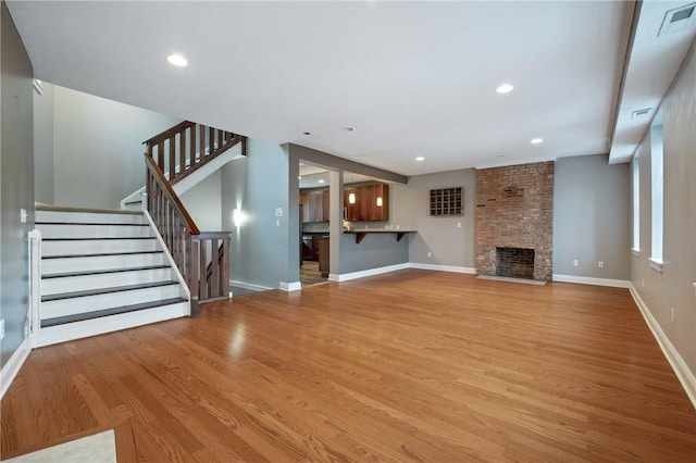 unfurnished living room featuring a fireplace and light hardwood / wood-style flooring