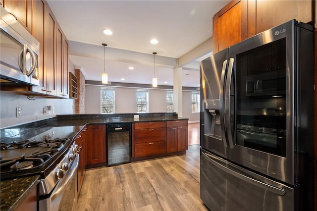 kitchen with wine cooler, dark stone countertops, decorative light fixtures, light hardwood / wood-style floors, and stainless steel appliances