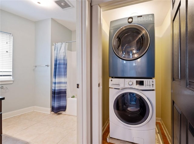 washroom with light tile patterned floors and stacked washer / dryer