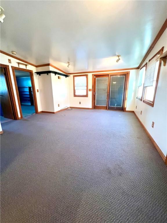 unfurnished living room with carpet flooring and crown molding