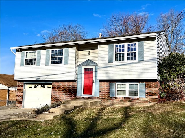 bi-level home with a garage and a front lawn