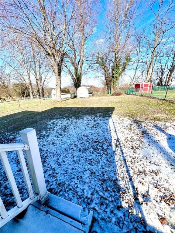 yard covered in snow featuring a storage shed