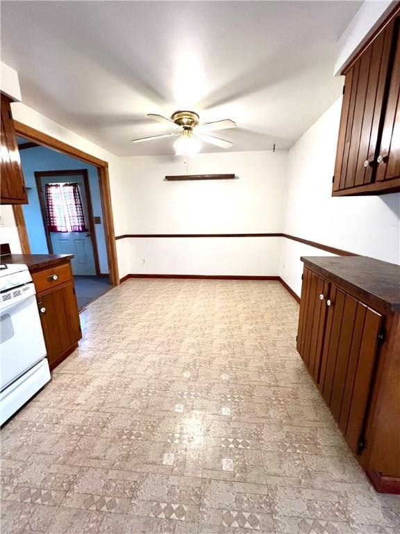 kitchen with ceiling fan, white range, and dark brown cabinetry