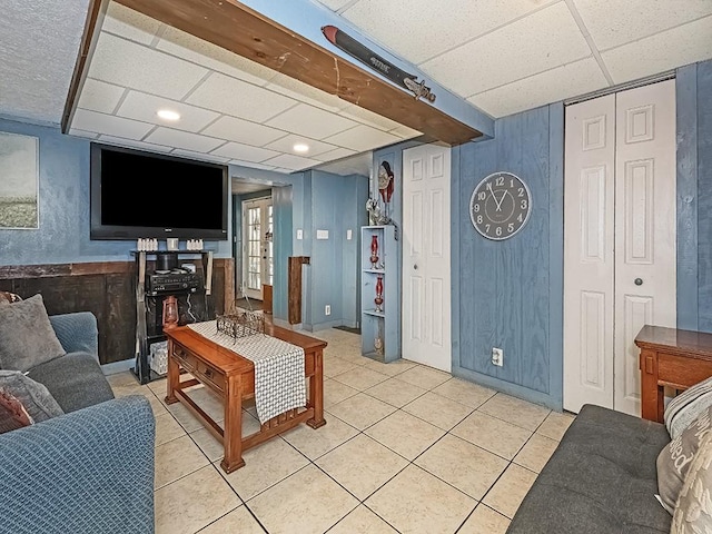 tiled living room with french doors and a paneled ceiling