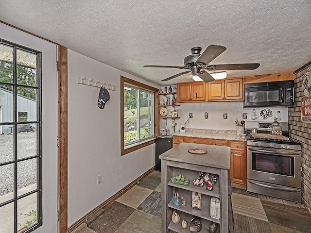 kitchen featuring plenty of natural light, ceiling fan, a textured ceiling, and gas range