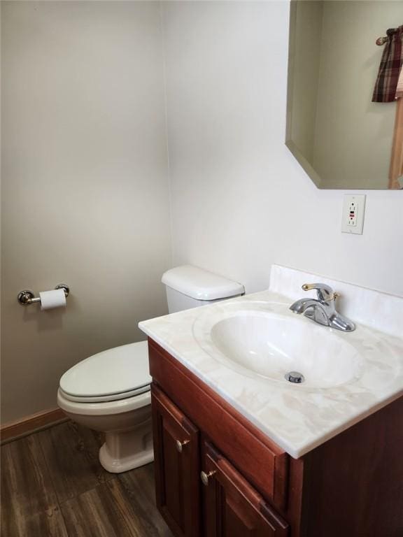 bathroom with hardwood / wood-style floors, vanity, and toilet