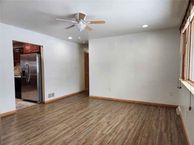 unfurnished room featuring ceiling fan, light hardwood / wood-style floors, and sink