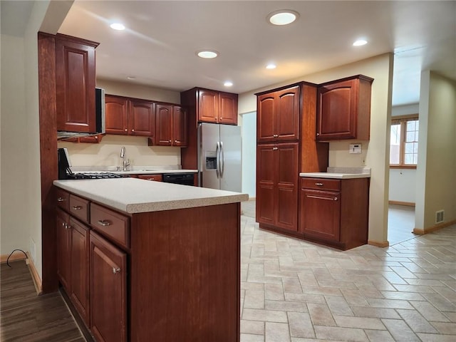 kitchen with stainless steel refrigerator with ice dispenser and sink