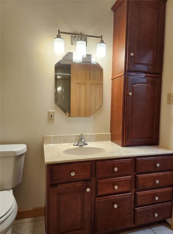 bathroom with tile patterned flooring, vanity, and toilet