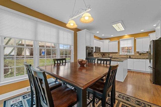 dining space featuring sink, plenty of natural light, and light wood-type flooring