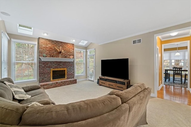 carpeted living room with crown molding and a brick fireplace