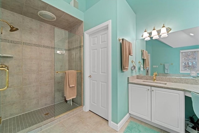 bathroom with tile patterned flooring, vanity, and walk in shower