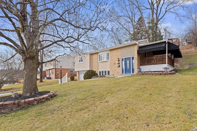 rear view of property with a garage and a yard