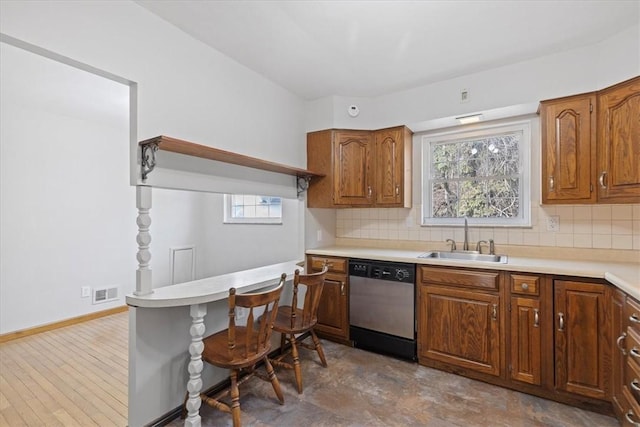 kitchen featuring dishwasher, a healthy amount of sunlight, sink, and tasteful backsplash