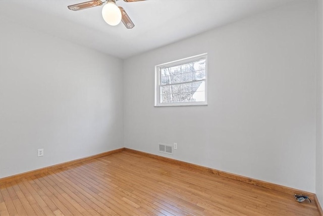 empty room with ceiling fan and light hardwood / wood-style flooring