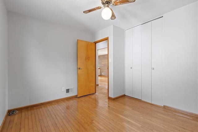 unfurnished bedroom featuring ceiling fan, light hardwood / wood-style flooring, and a closet