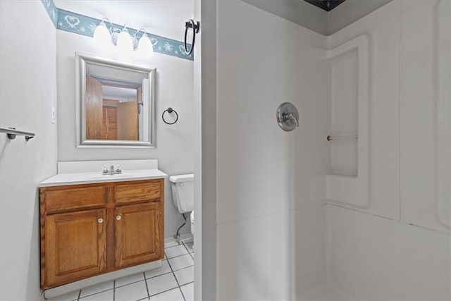 bathroom with a shower, vanity, tile patterned floors, and toilet