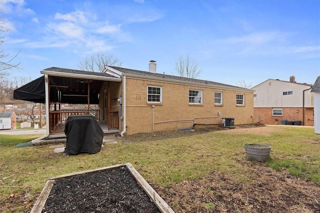 rear view of property with a yard and central AC