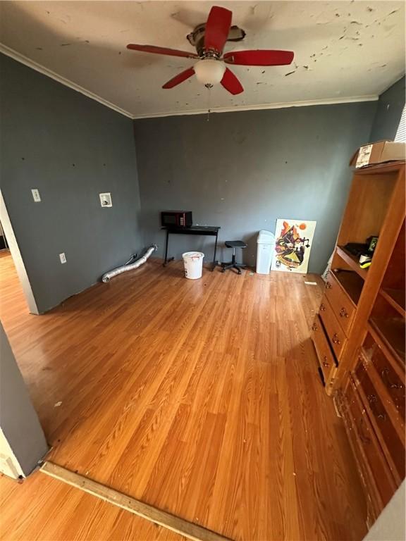 unfurnished living room with hardwood / wood-style floors, ceiling fan, and ornamental molding