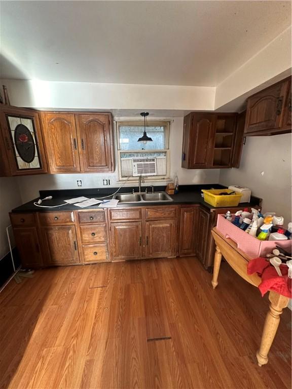 kitchen featuring light wood-type flooring, sink, and hanging light fixtures