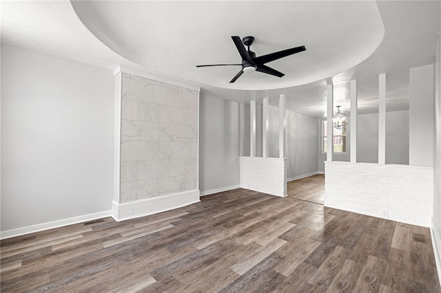 empty room with ceiling fan with notable chandelier and hardwood / wood-style flooring