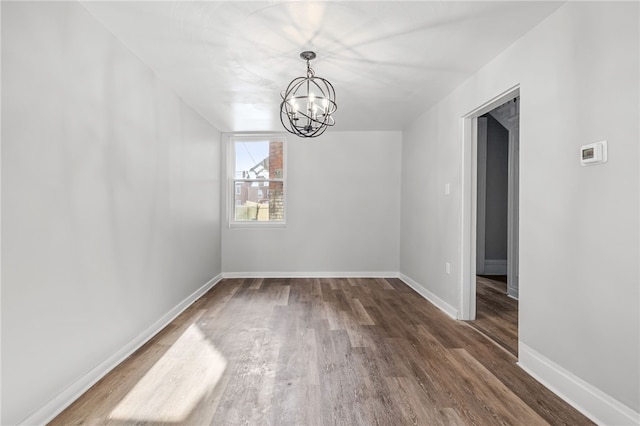 unfurnished dining area featuring dark hardwood / wood-style floors and an inviting chandelier